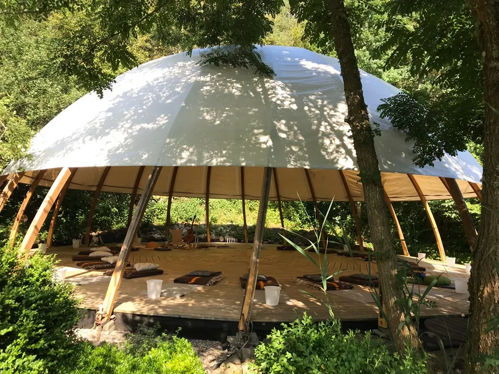 Meditationsdomen omgivet af skoven på et retreat i Sverige