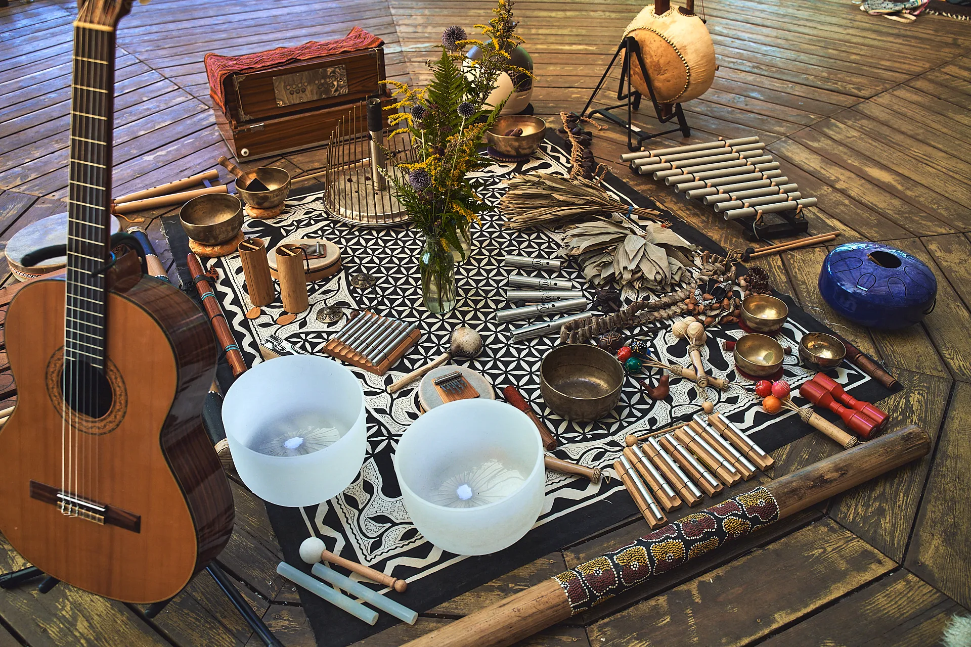 Sound healing instruments — singing bowls, chimes, guitar and didgeridoo — laid out for a session